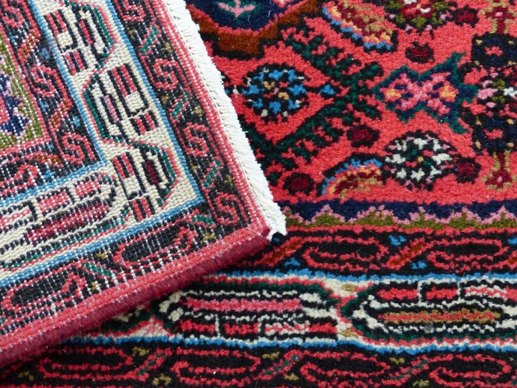 Luxe Perzisch tapijt met traditioneel patroon in warme kleuren toegepast in een modern huiskamerinterieur